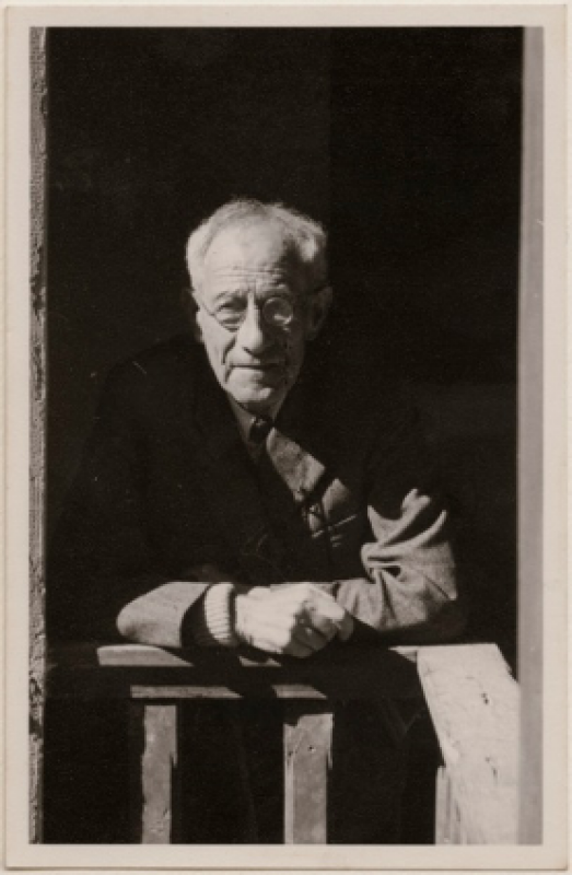 Black and white photograph of Paul Oppe leaning on a fence.
