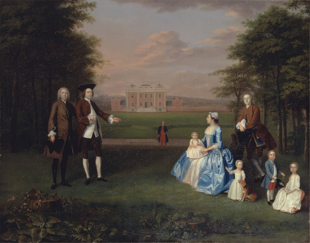 Two men standing opposite family in garden with house in distance