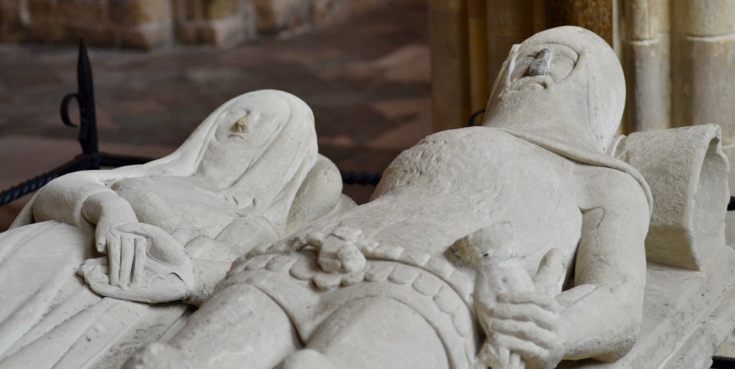 Sculpted figures laying down, hands clasped